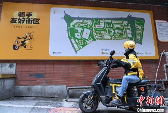 图为重庆市沙坪坝区渝碚路街道新体村社区一小区，骑手在看骑手地图。沙坪坝区融媒体中心供图