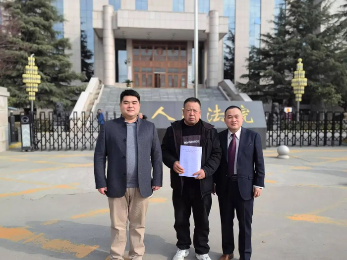 ▲2024年3月15日，姚敏（中）拿到侵权责任纠纷案一审判决结果，和代理律师喻胜修在法院门口合影。受访者供图