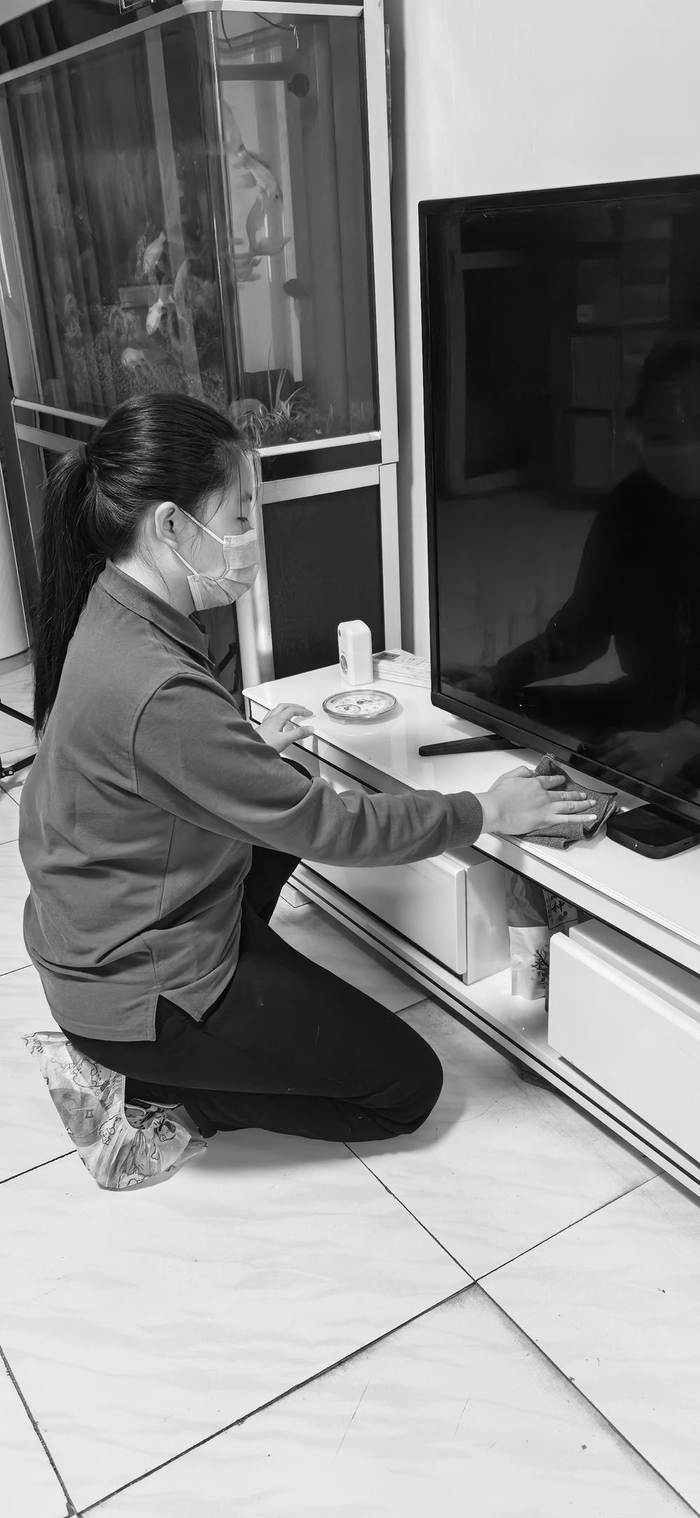 　　▲图为家政服务人员在为用户清洁客厅电视柜。