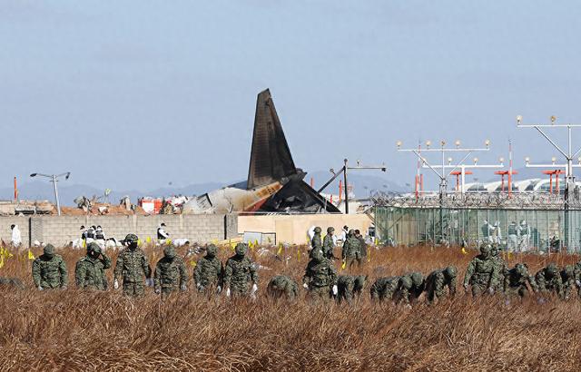 2024年12月31日，韓國務(wù)安國際機場，警方科學(xué)調(diào)查隊正在對濟州航空客機事故進行現(xiàn)場調(diào)查。視覺中國 圖