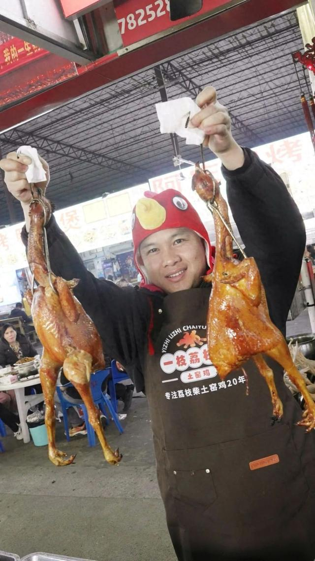 梁定仁举着新鲜出炉的烤鸡。唐绍怡 摄