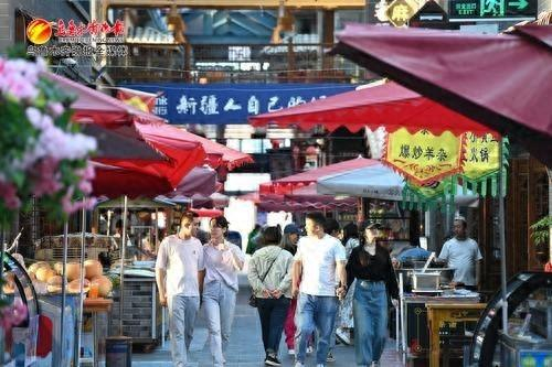 　　2024年7月7日21时17分，在乌鲁木齐县水西沟镇闲来小镇宽窄巷子文旅步行街，游客正在寻找美食。资料图片