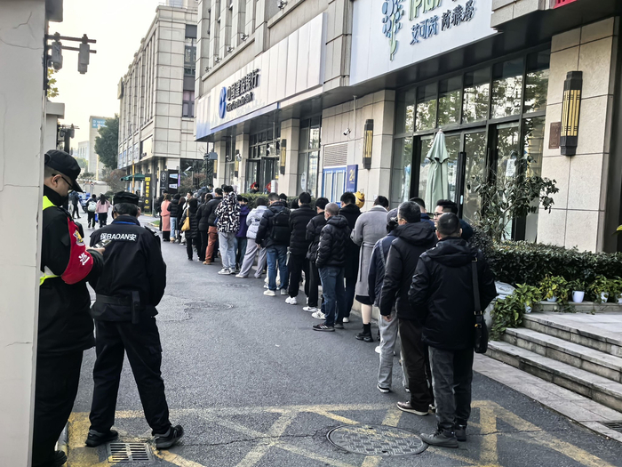 银行门口等待兑换纪念币、纪念钞的长队，时代周报记者摄。