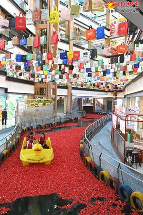 　　2024年4月30日，在米东区米古里室内河道鲜花水道，游客乘坐游船在玫瑰花海里拍照打卡。资料图片