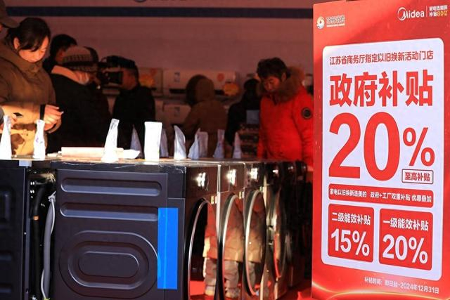 2024年12月21日，江苏省淮安市，市民在汽车家电家居迎新惠民集市购物消费。 视觉中国 图