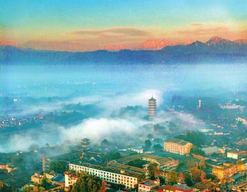 2024年12月30日，成都市元通古镇在朝霞中苏醒，古塔后雪山巍峨。