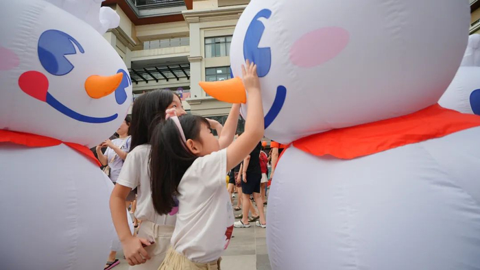 蜜雪冰城马来西亚店庆活动，“雪王”玩偶与当地小朋友互动