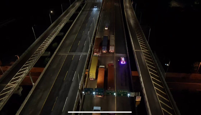 团雾天气，集卡车在警车引导下有序通过东海大桥。洋山公安处供图