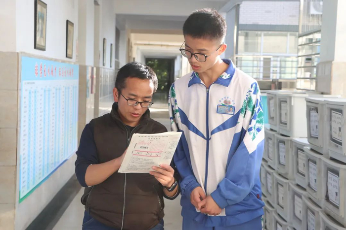 王晓明（左）为学生讲题。图源：云南日报