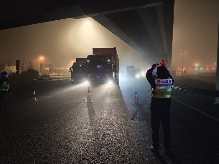 团雾天气，民警在东海大桥有序引导集卡车通行。洋山公安处供图