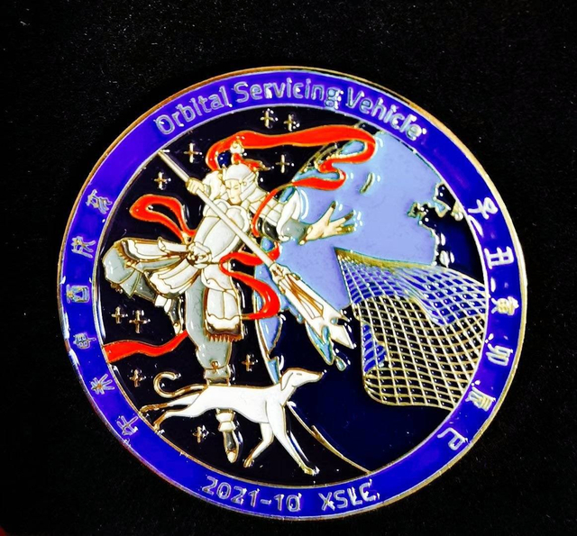 据说是实践二十一号的任务徽章，设计非常有趣，二郎神带着哮天犬撒出天网，捕获某种目标 作者供图 
