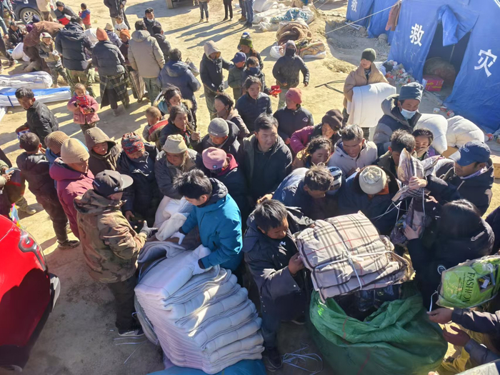 灾民们正在接受救援物资。受访者 图