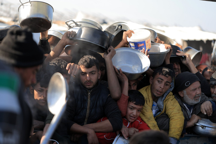 当地时间2024年12月31日，加沙地带汗尤尼斯，巴勒斯坦民众领取慈善机构分发的救济食物。图/IC photo