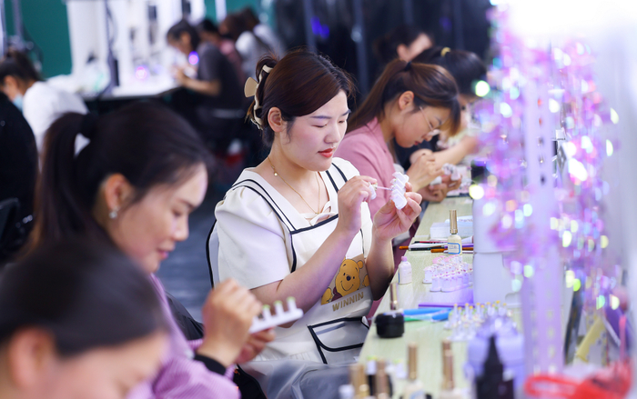 ● 东海县某美妆公司正在制作穿戴甲的女性。图片来源：新华日报