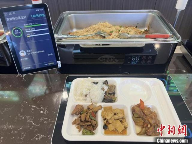 将装好食物的托盘放在指定感应区，饭菜重量、营养成分、消费金额即刻在屏幕上显现。刘天宇供图