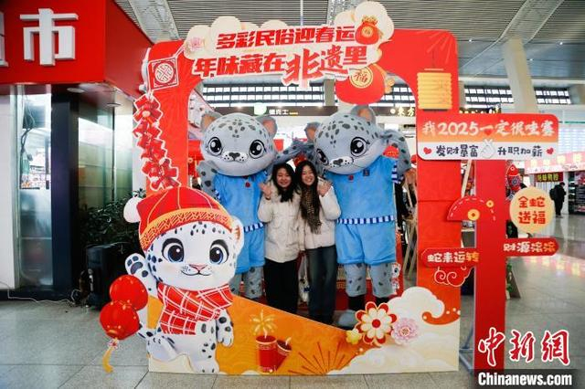 1月14日，西宁火车站，旅客在非遗集市打卡处留影。中新社记者 马铭言 摄 中新社记者 马铭言 摄 