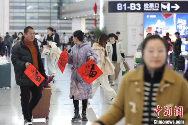 图为旅客带着书法家现场书写的“福”字候车。中新社记者 泱波 摄 