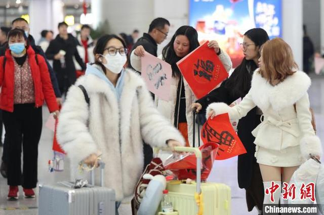 图为旅客带着书法家现场书写的“福”字候车。中新社记者 泱波 摄 