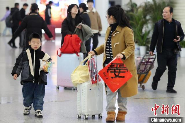 图为旅客带着书法家现场书写的“平安”字候车。中新社记者 泱波 摄 