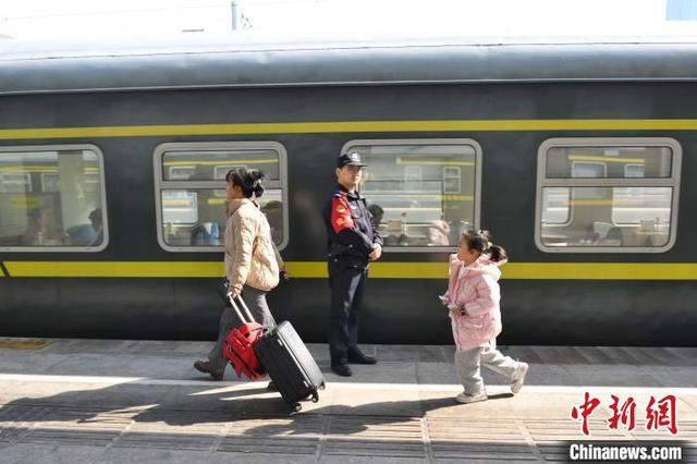 图为家长带着孩子赶火车。中新社记者 杨华峰 摄