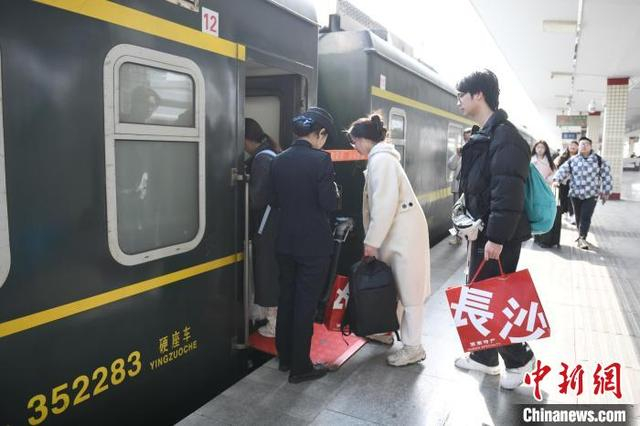 图为旅客提着礼品登上列车。中新社记者 杨华峰 摄
