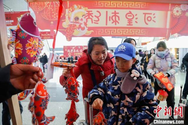 1月14日，西宁火车站，旅客在非遗集市上了解青绣产品。中新社记者 马铭言 摄 