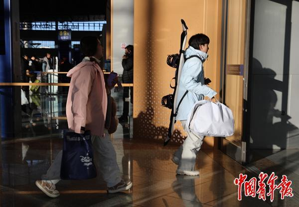 1月14日，北京朝阳站候车大厅，一位年轻的旅客背着滑雪板进站准备乘车。中青报·中青网记者 陈剑/摄