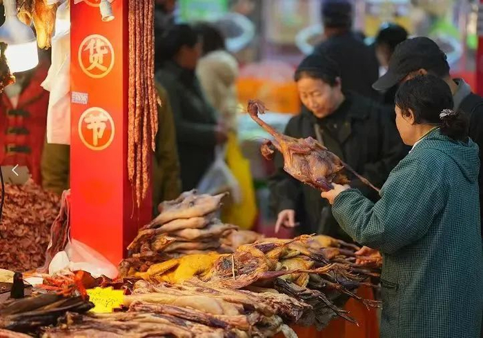 顾客正在和谐世纪广场年货街挑选腊鸭
