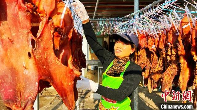 经过腌制后的猪头皮，挂在铁丝架子上，或是借助自然风和太阳光进行风干。熊川摄