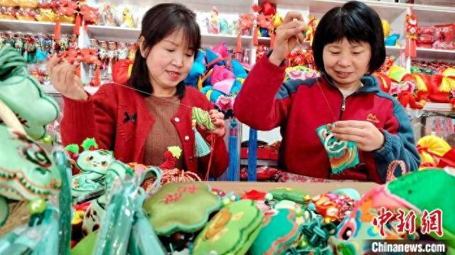 1月17日，甘肃庆阳市，绣娘们在刺绣工作室赶制新春香包。盘小美 摄