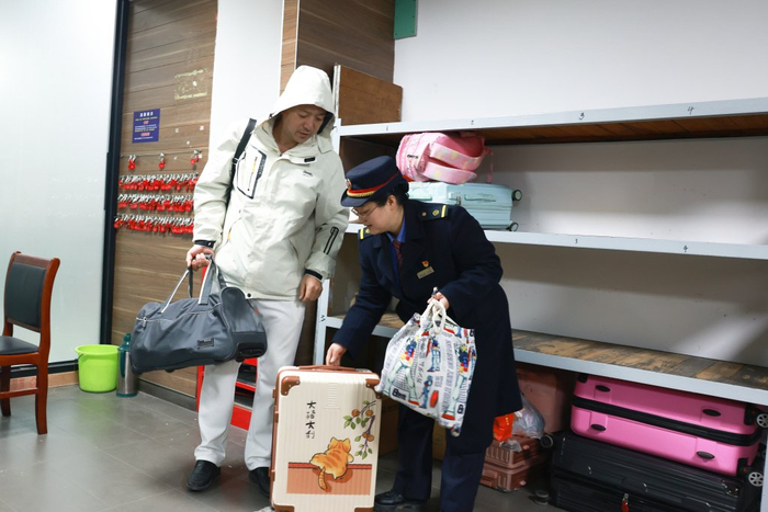 南昌站工作人员正在为旅客办理免费寄存行李业务。刘慕 图