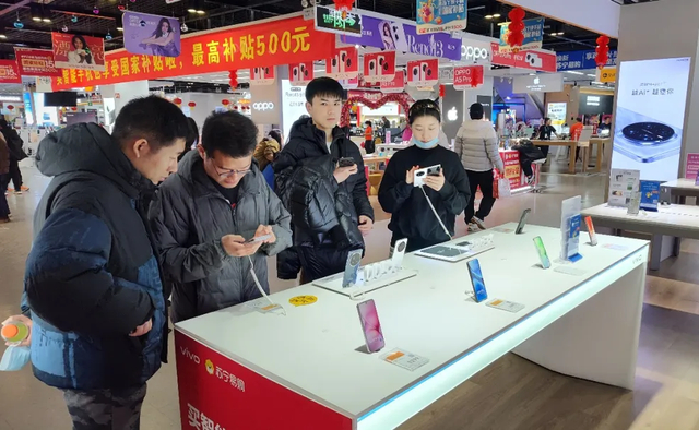 图为消费者正在商场选购手机。