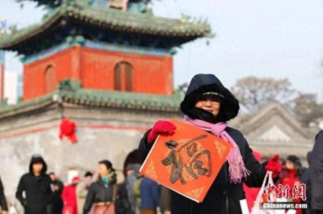 资料图：农历腊月廿三小年来临，北京东岳庙举办迎新春送春联活动，参与者甚众。中新社记者 富田 摄 