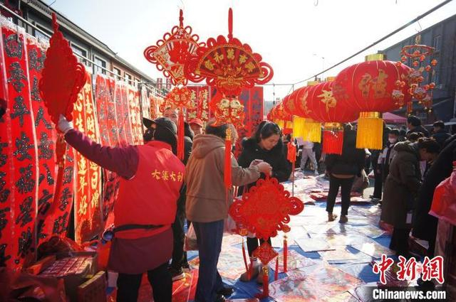 1月22日，天津，民众在芦台大集上购买春节民俗挂饰。中新社记者 佟郁 摄