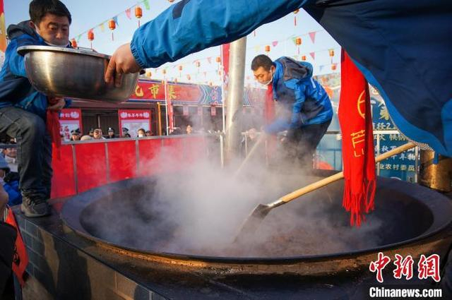 1月22日，天津，工作人员在天津芦台大集上制作腊肉饭。中新社记者 佟郁 摄