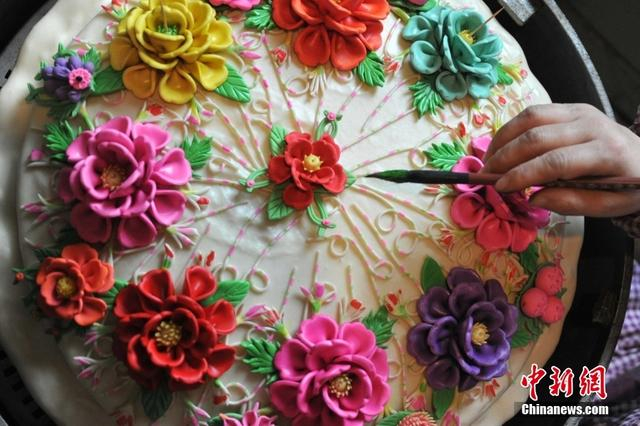 图为闻喜县的花馍艺人在自家作坊为客户赶制新年花馍。