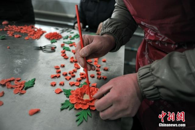 图为闻喜一馍业公司的花馍艺人在制做花馍插花。