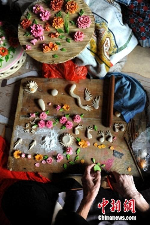 图为闻喜花馍艺人在制做花馍插花。