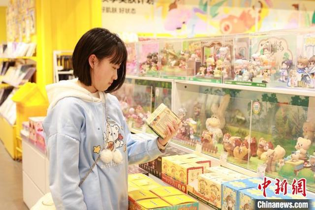 图为年轻人在选购动漫周边盲盒。中新社记者 林馨 摄