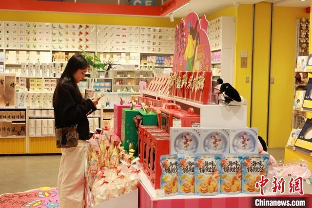 图为年轻人在“谷子店”选购商品。中新社记者 林馨 摄