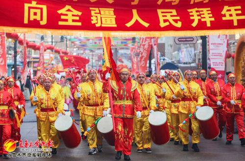　　水磨沟区石人子沟社火队在大巴扎步行街巡游。 记者米热扎提·木塔力甫摄