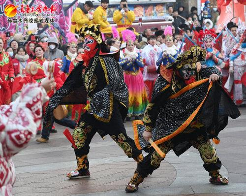 　　天山区社火表演队正在展演川剧变脸。记者陈岩摄