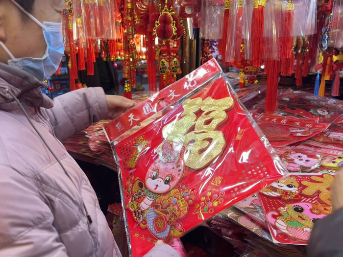 2025年1月23日，上海福佑商厦，周女士给女儿挑门贴。