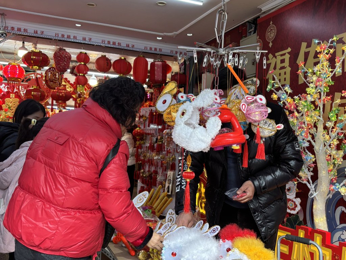 2025年1月23日，上海福佑商厦外，市民正在选购新春饰品。