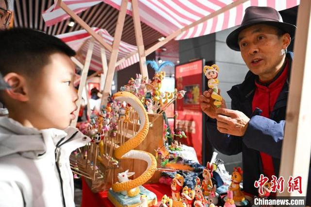图为非遗面塑传承人在重庆市群众艺术馆向小朋友介绍“重庆面塑”。中新社记者 何蓬磊 摄