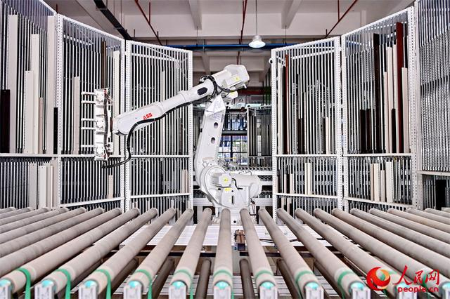 位于赣州市南康区的一家家具零部件共享智能工厂内，机械臂正在批量加工家具零部件。人民网 朱海鹏摄