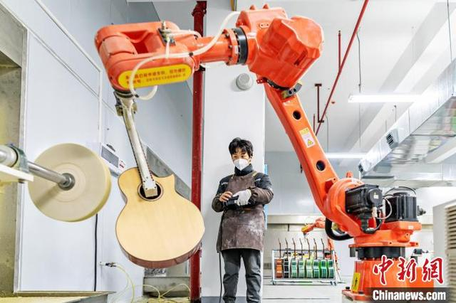 湖南永州市东安县吉他生产引入机械臂。蔡小平 摄
