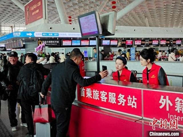图为郑州机场工作人员为旅客解答问题。薛奥林 摄