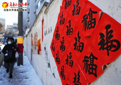 　　在水磨沟区新民东街南二巷，墙上贴满了各种字体的“福”字（1月25日摄）。记者雷婷摄