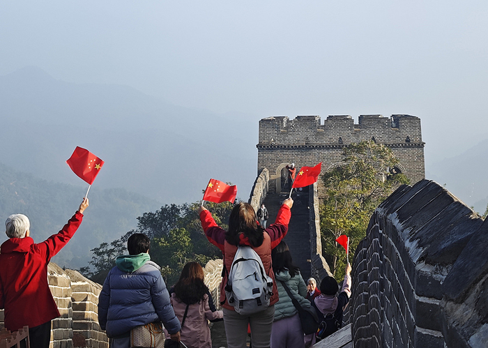2024年9月25日，河北省承德市滦平县，在金山岭长城上，游客手持国旗留影。视觉中国 资料图